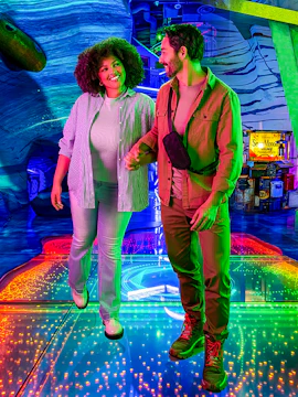 Couple exploring colorful interactive exhibit at Omega Mart, Las Vegas.