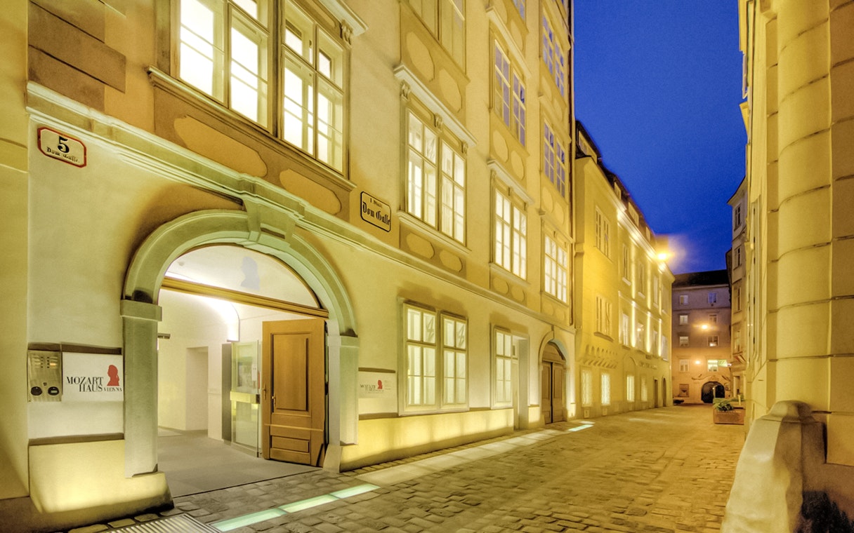 Exterior of Mozarthaus Vienna at night with illuminated windows.
