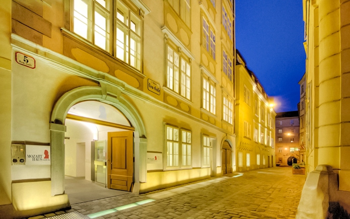Exterior of Mozarthaus Vienna at night with illuminated windows.