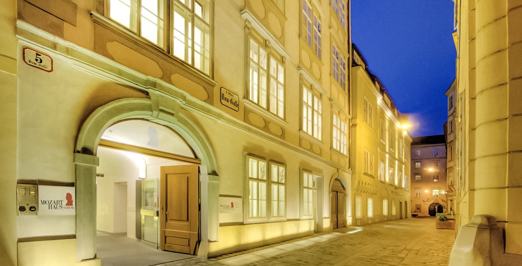 Exterior of Mozarthaus Vienna at night with illuminated windows.
