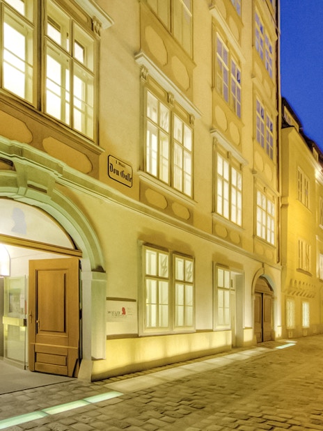 Exterior of Mozarthaus Vienna at night with illuminated windows.