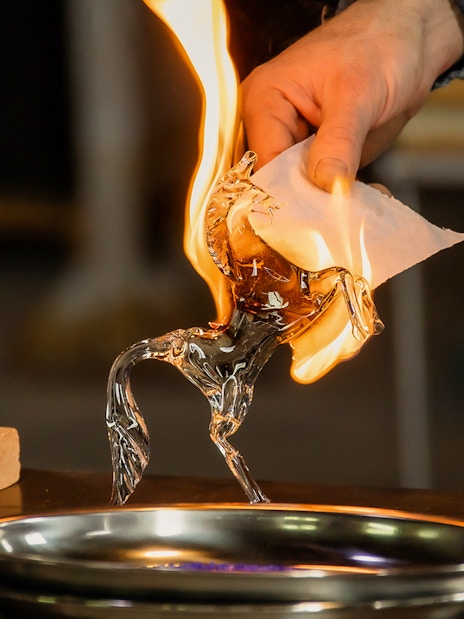 Glassblowing demonstration in Murano, Venice with a flaming glass horse sculpture.