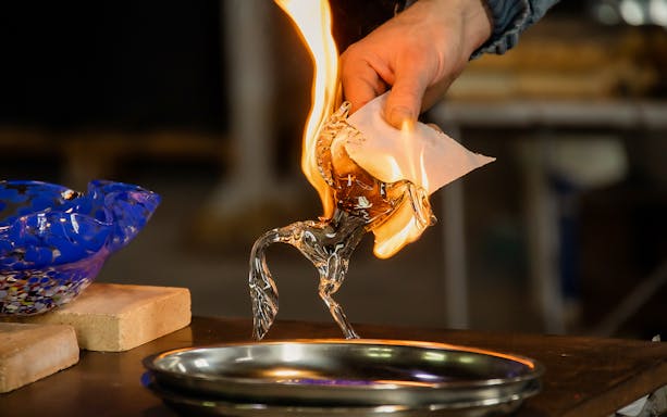 Glassblowing demonstration in Murano, Venice with a flaming glass horse sculpture.