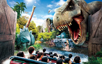 Visitors on a boat ride encounter dinosaurs at Jurassic Park: The Ride, Universal Studios Japan.