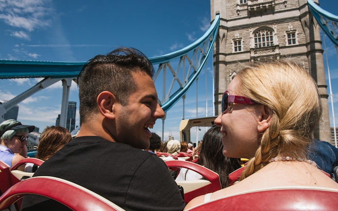 Open-top bus tour crossing Tower Bridge in London.