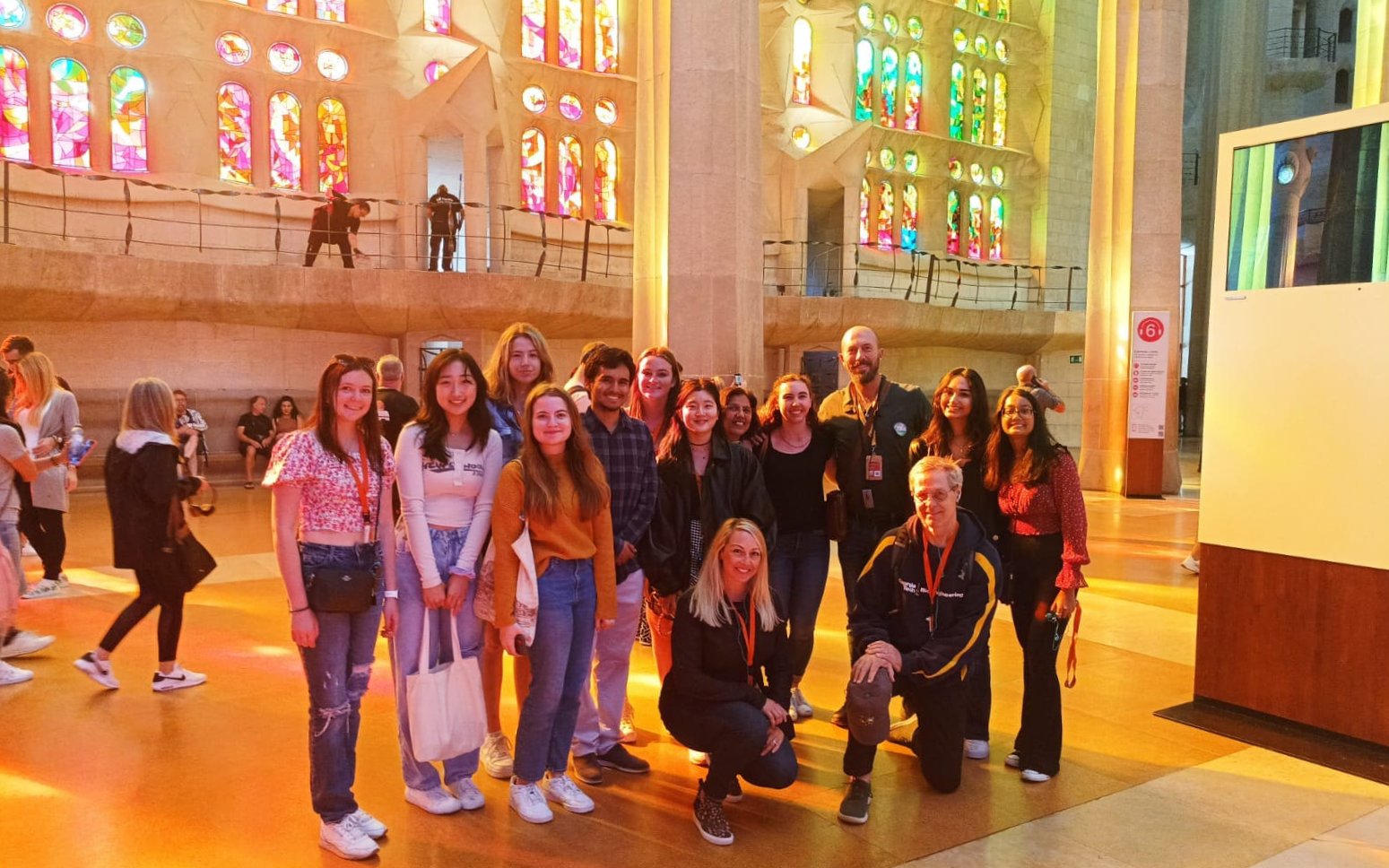 Tour group with guide in front of stained glass windows at Sagrada Familia, Barcelona.