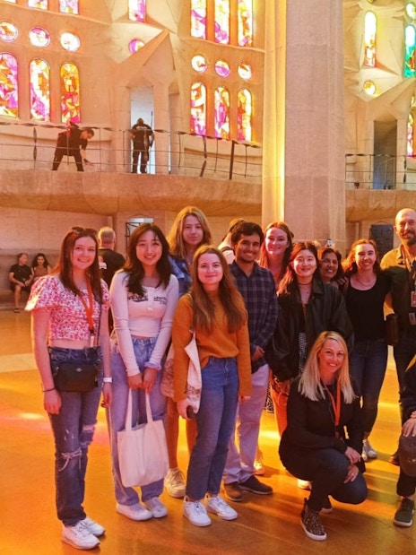 Tour group with guide in front of stained glass windows at Sagrada Familia, Barcelona.