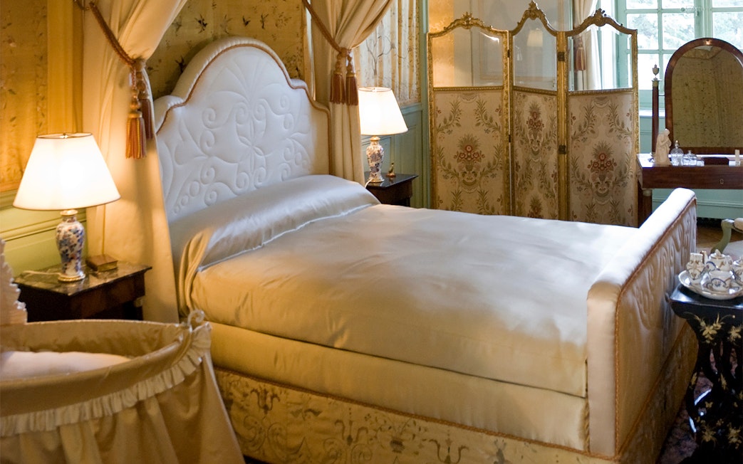 Luxurious bedroom in a Loire Valley château with ornate decor and elegant furnishings.