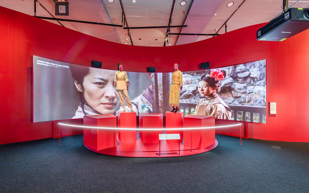 Exhibit at Art Science Museum's Future World featuring film costumes and screen display.