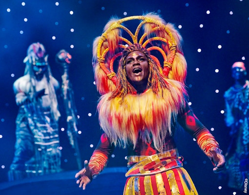 The Lion King: Rhythms of the Pride Lands show at Disneyland Paris featuring performers in vibrant costumes.