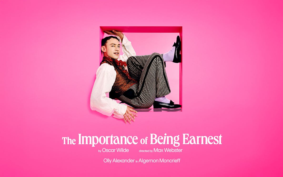 Actor in costume for "The Importance of Being Earnest" against a pink background.