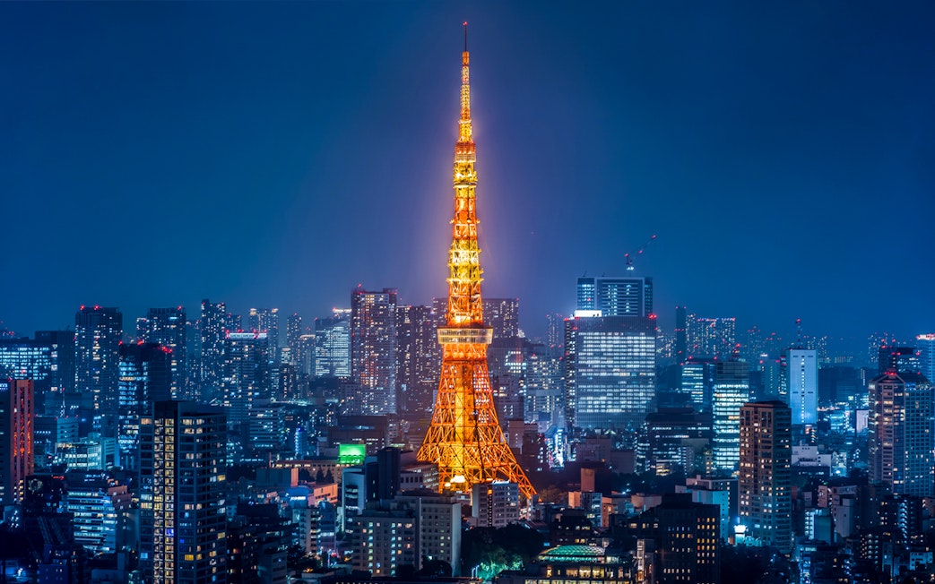 Tokyo Tower illuminated at night with city skyline.
