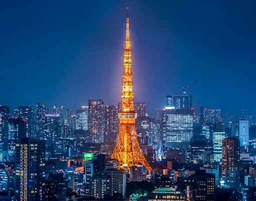 Tokyo Tower illuminated at night with city skyline.