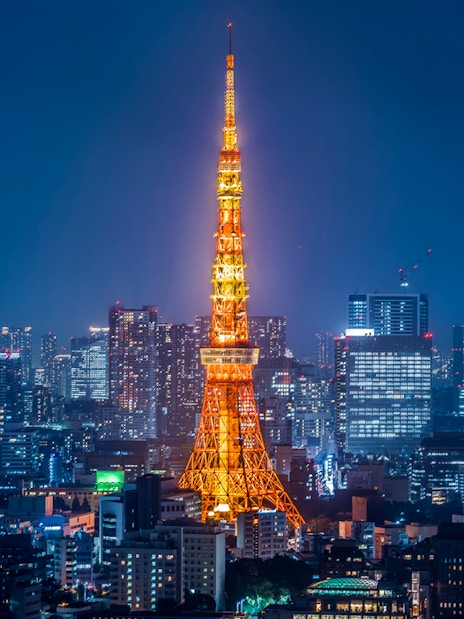 Tokyo Tower illuminated at night with city skyline.