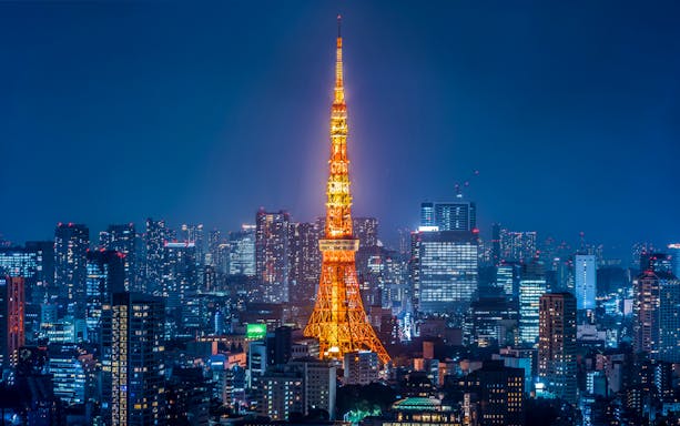 Tokyo Tower illuminated at night with city skyline.