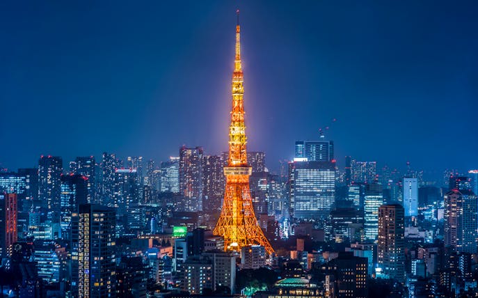 Tokyo Tower illuminated at night with city skyline.