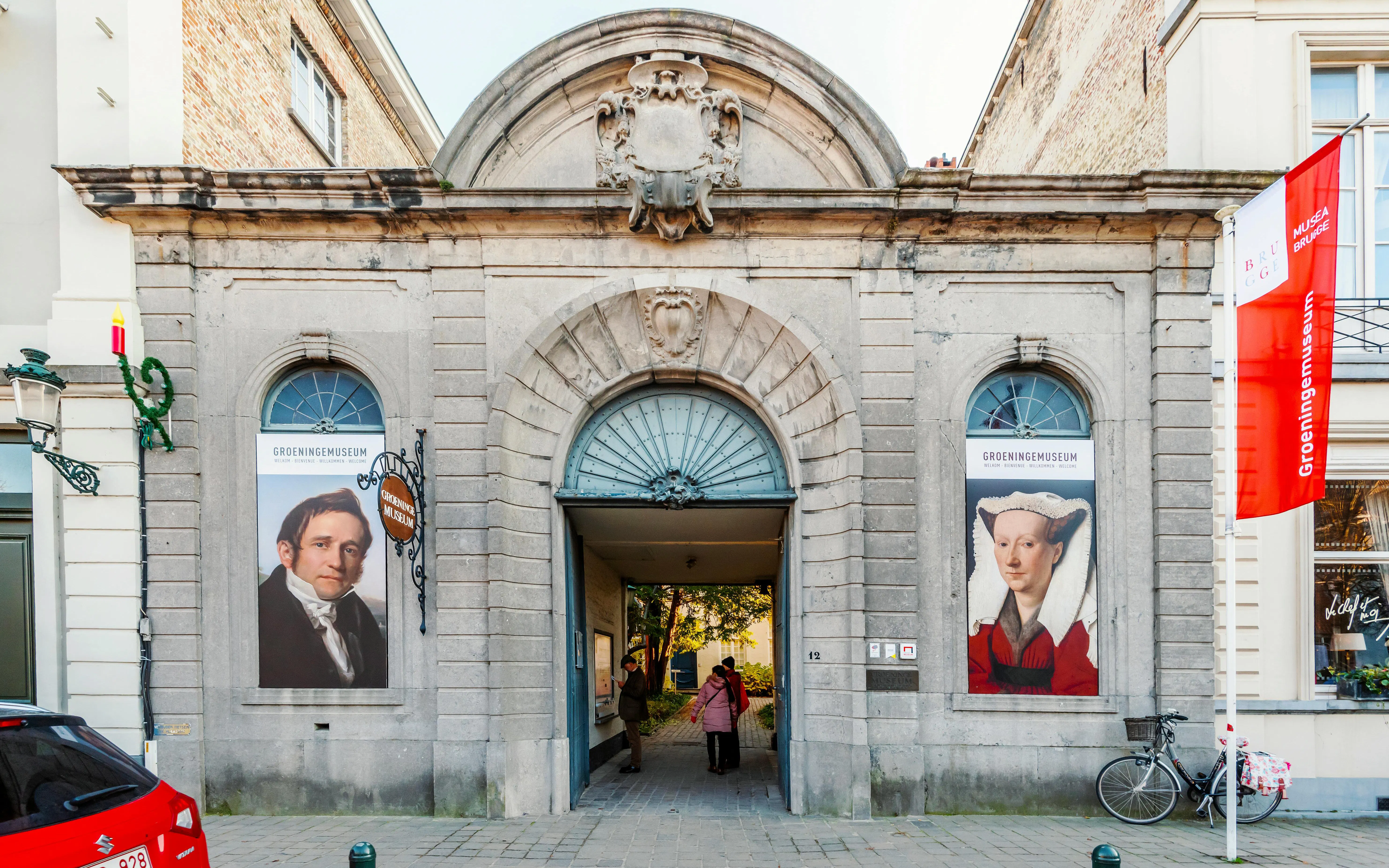 Groeningemuseum entrance with historical portraits in Bruges, Belgium.