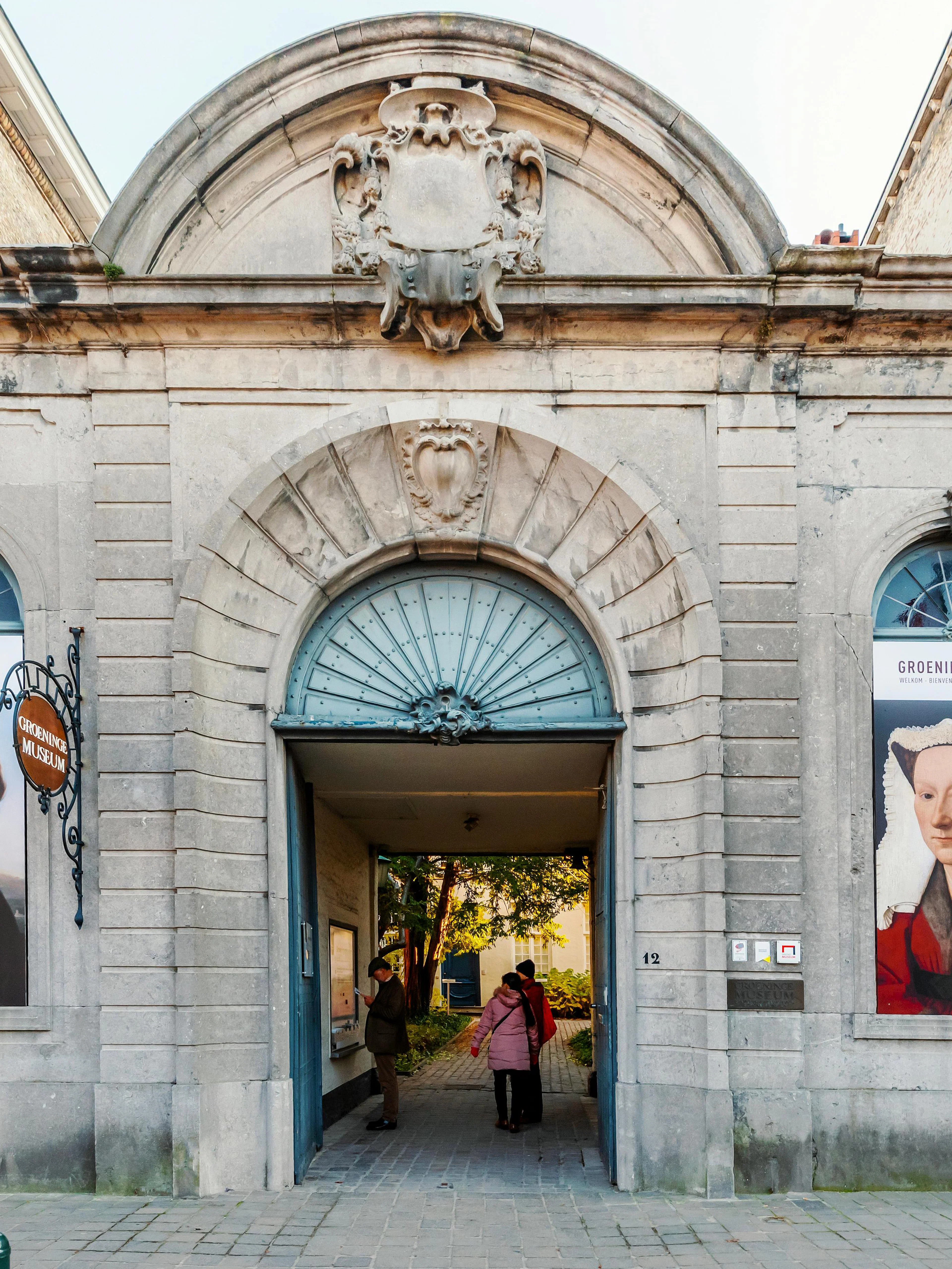 Groeningemuseum entrance with historical portraits in Bruges, Belgium.