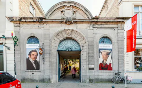 Groeningemuseum entrance with historical portraits in Bruges, Belgium.