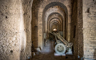 Canons inside Gjirokaster Castle, Albania, in a stone-arched corridor.