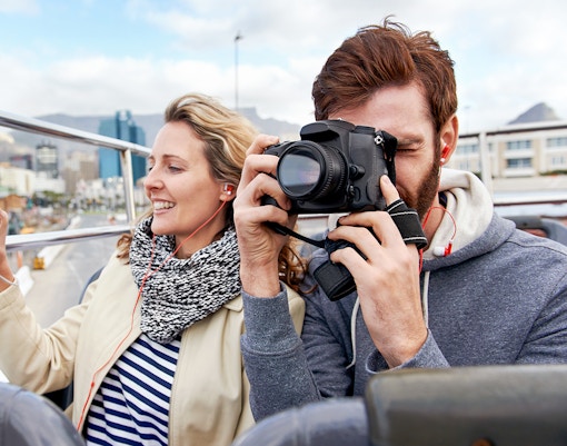 Couple taking photos on a Hop on Hop off bus in Medina.