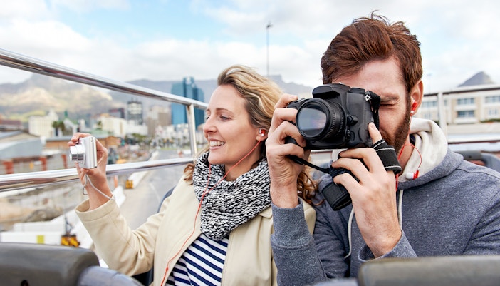 Couple taking photos on a Hop on Hop off bus in London.
