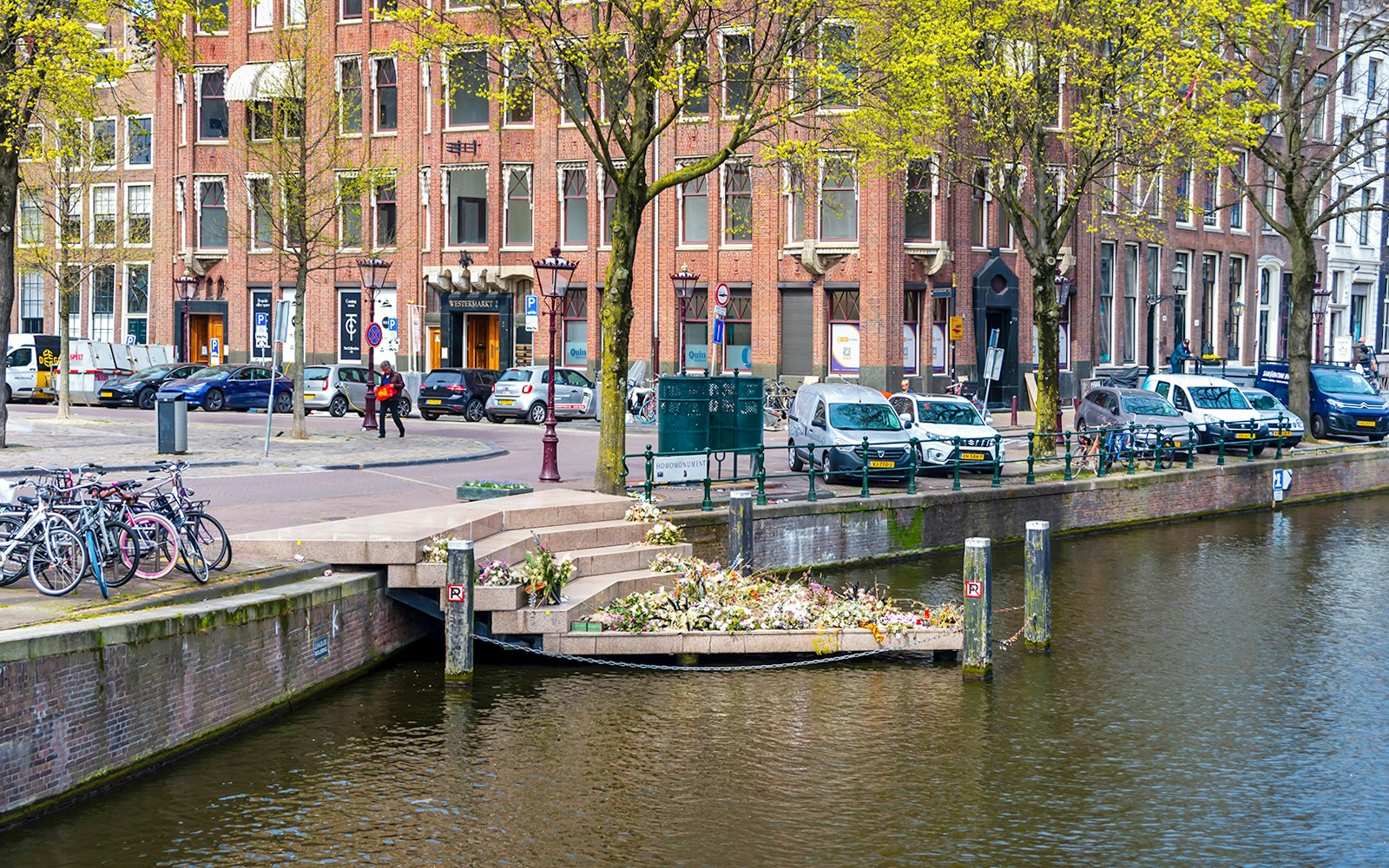 Amsterdam canal view with bicycles and Westerkerk near Anne Frank House.