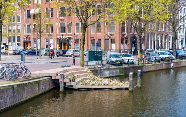 Amsterdam canal view with bicycles and Westerkerk near Anne Frank House.