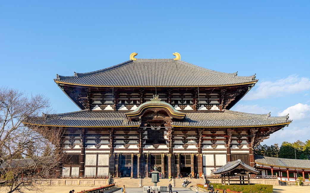 Tōdai-ji Temple's Great Buddha Hall in Nara, Japan, with visitors exploring the grounds.