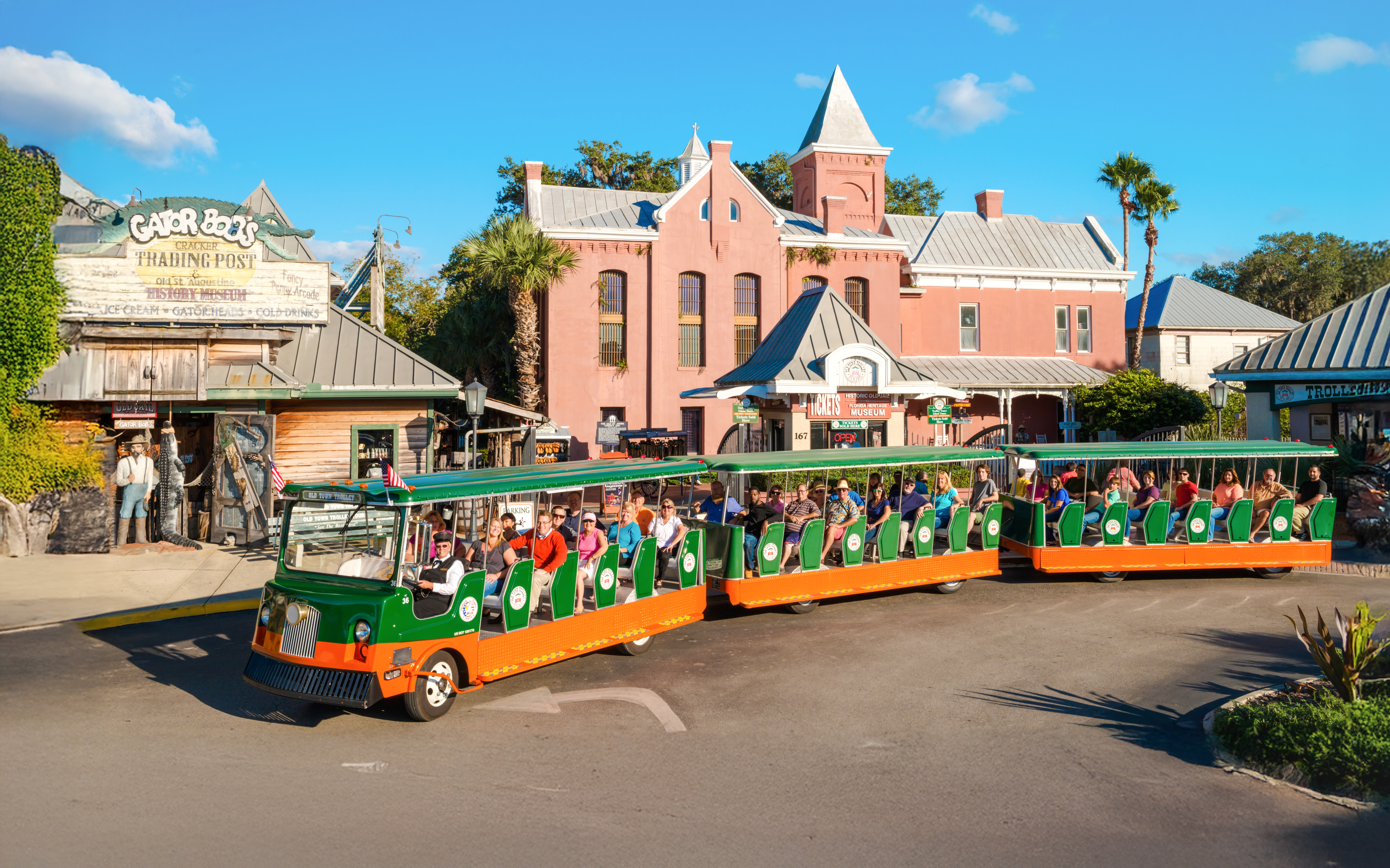 Old Town Trolley with tourists passing Gator Bob’s Trading Post in St. Augustine.
