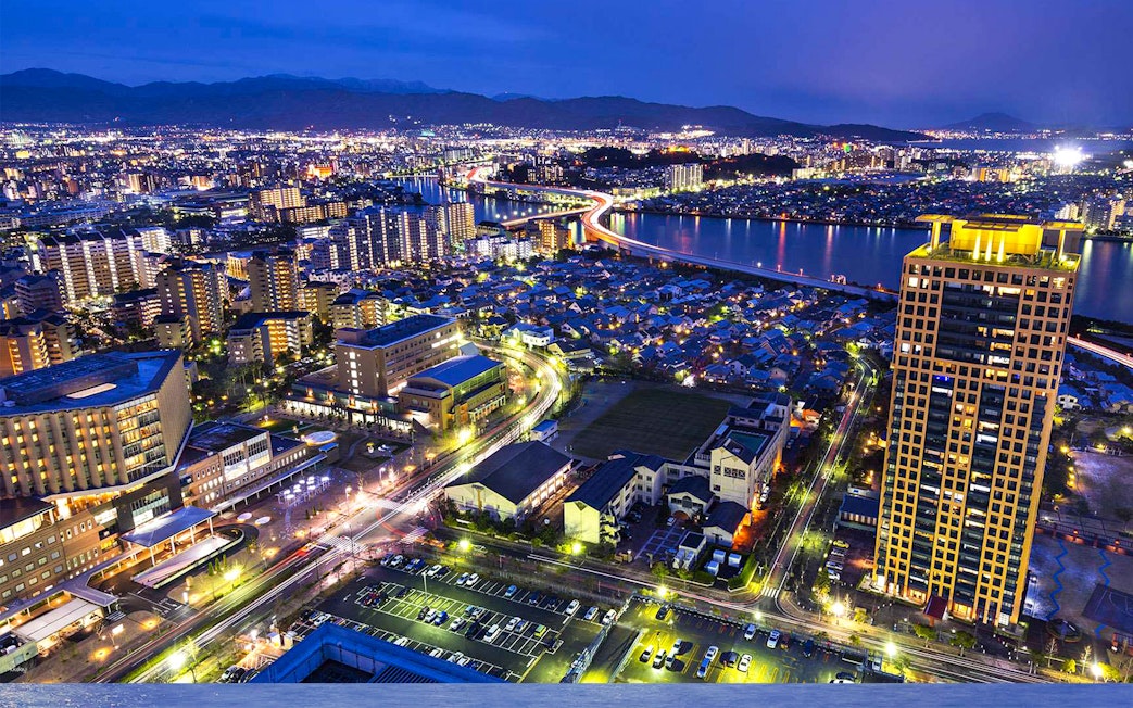 Fukuoka cityscape at night with illuminated buildings and river view from Fukuoka Tower.