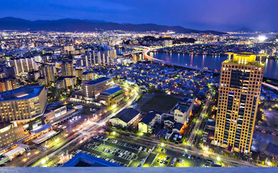 Fukuoka cityscape at night with illuminated buildings and river view from Fukuoka Tower.