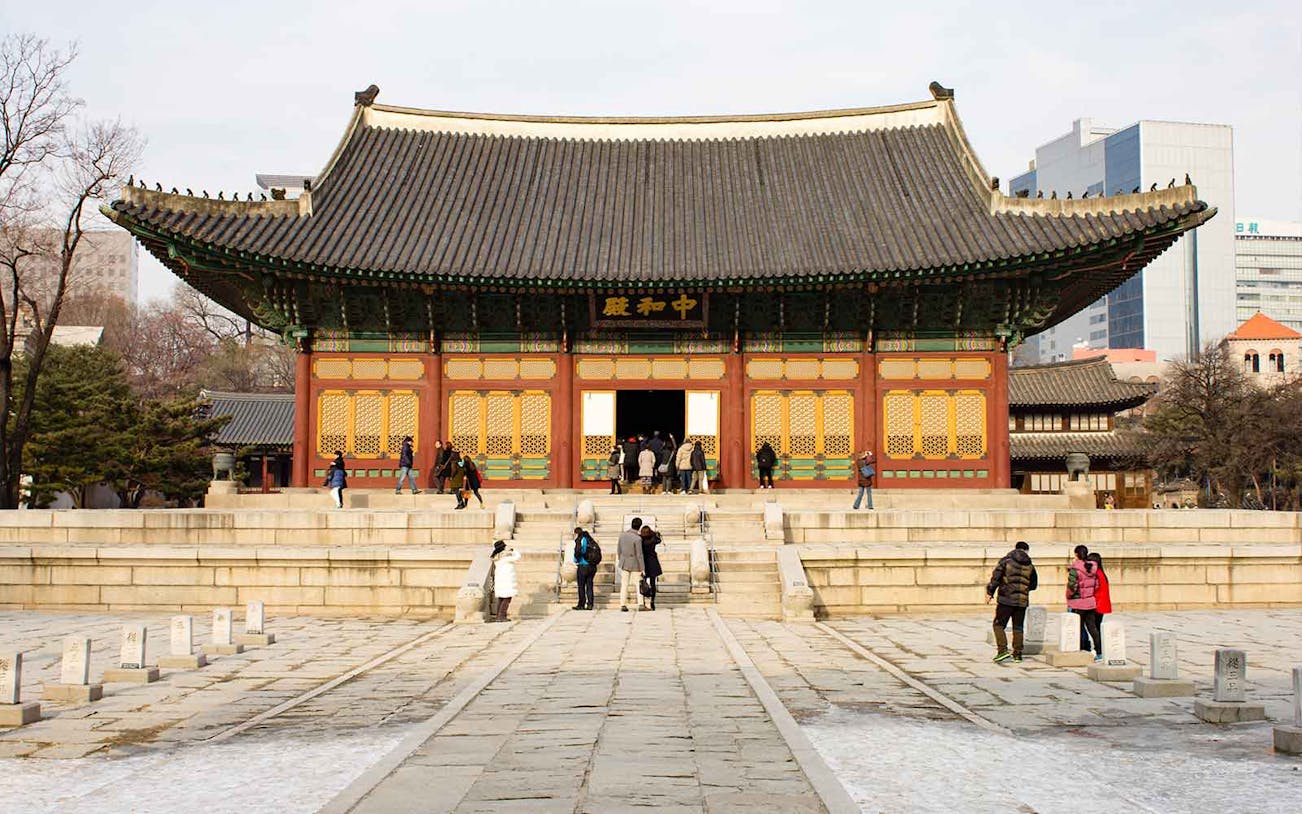 Visitors exploring the courtyard of Deoksugung Palace in Seoul, South Korea.
