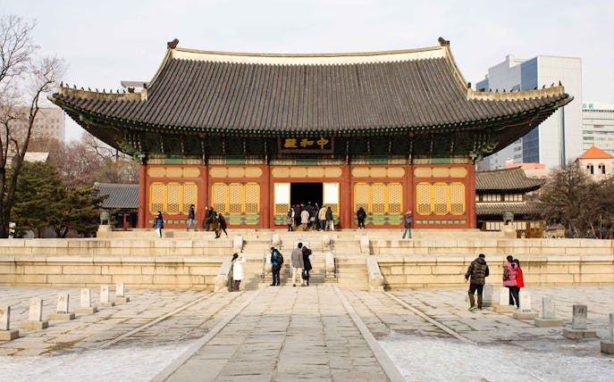 Visitors exploring the courtyard of Deoksugung Palace in Seoul, South Korea.