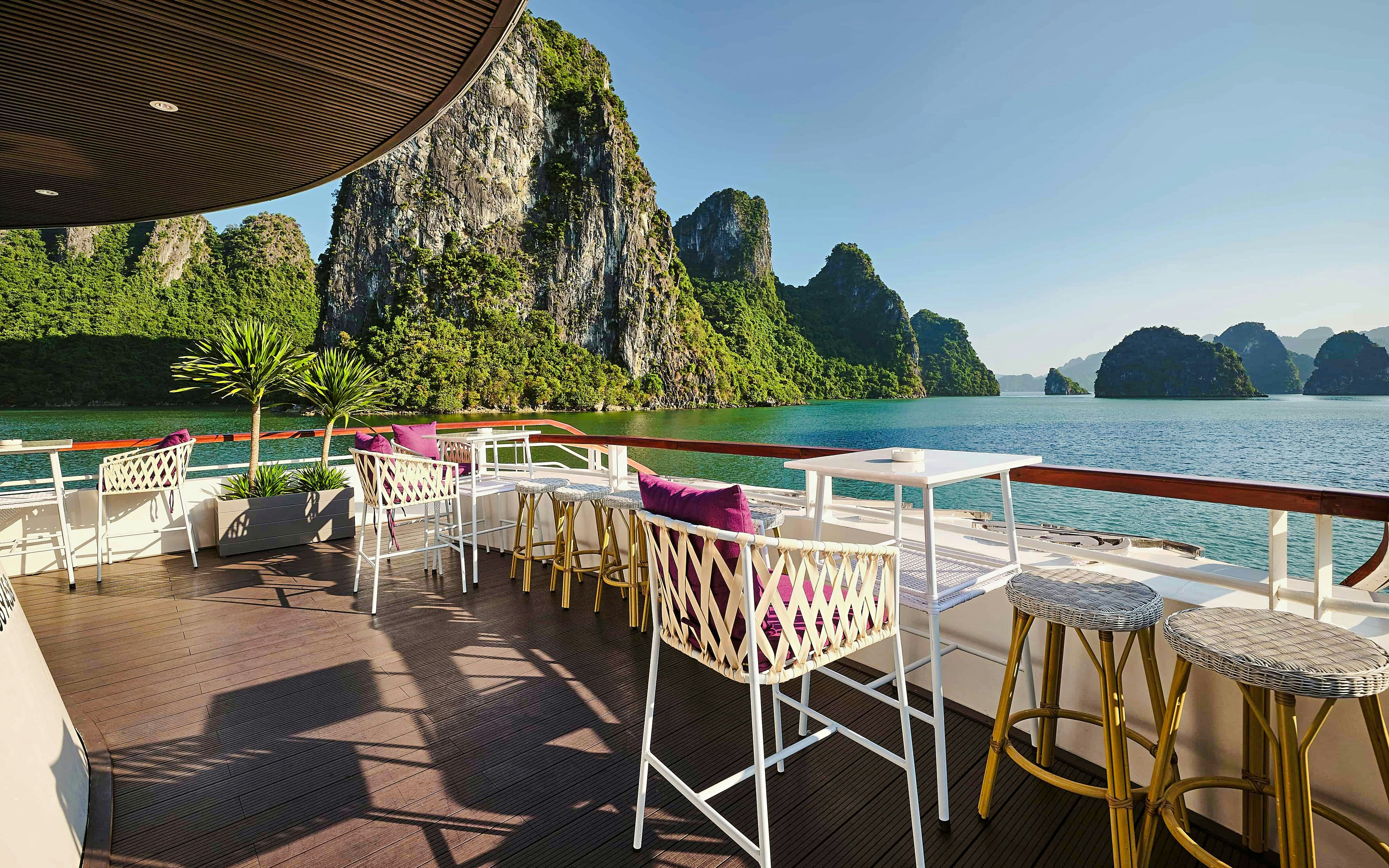 Outdoor seating area on Iris Halong Cruise with view of Ha Long Bay, Vietnam.