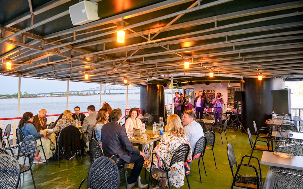 Guests dining while Dukes play live jazz on Steamboat Natchez cruise in New Orleans.