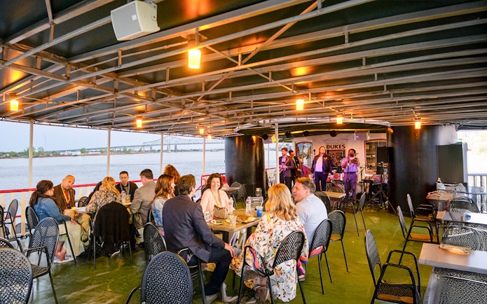Guests dining while Dukes play live jazz on Steamboat Natchez cruise in New Orleans.
