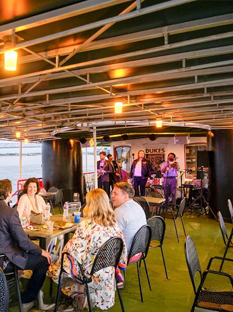 Guests dining while Dukes play live jazz on Steamboat Natchez cruise in New Orleans.
