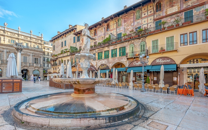 Fountain in Piazza delle Erbe with Palazzo Maffei in Verona, Italy.