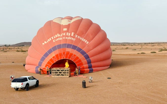 Crew inflating hot air balloon in Marrakech desert.