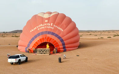 Crew inflating hot air balloon in Marrakech desert.
