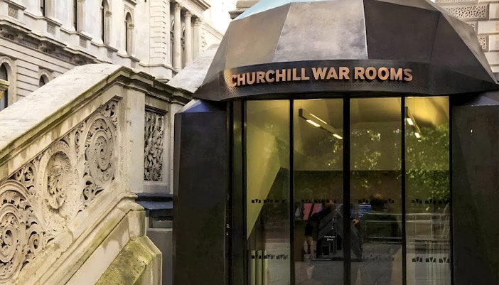 Entrance to Churchill War Rooms in London with ornate stone staircase.
