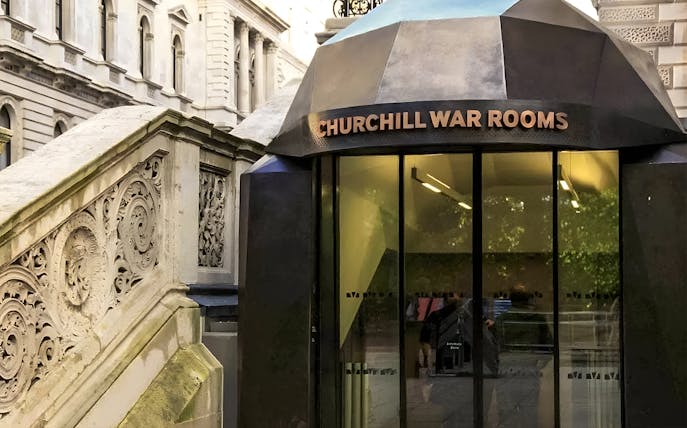 Entrance to Churchill War Rooms in London with ornate stone staircase.
