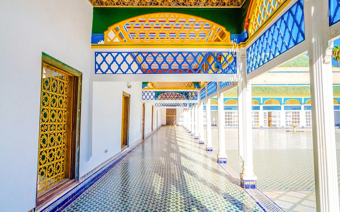 Bahia Palace courtyard with colorful arches and tiled floor in Marrakech, Morocco.
