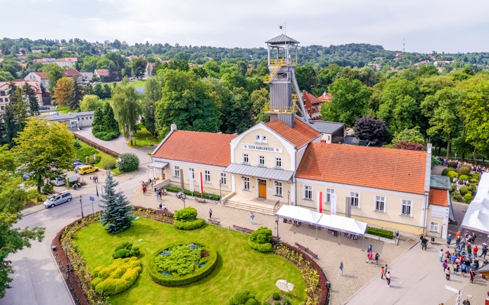 Aerial view of Wieliczka Salt Mine entrance with surrounding greenery and visitors.
