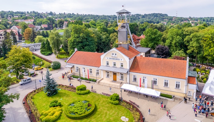 Aerial view of Wieliczka Salt Mine entrance with surrounding greenery and visitors.