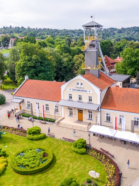 Aerial view of Wieliczka Salt Mine entrance with surrounding greenery and visitors.