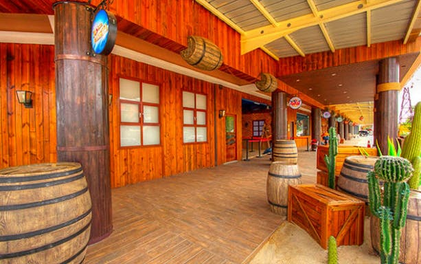 Wild West-themed wooden storefront with barrels and cacti.