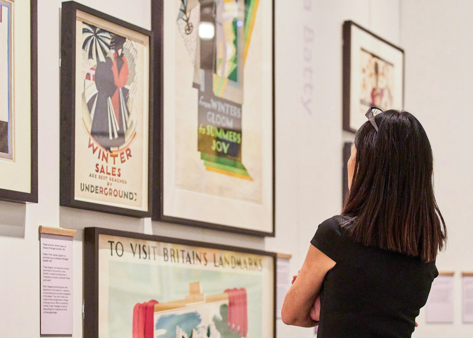 Visitor viewing vintage posters at London Transport Museum.