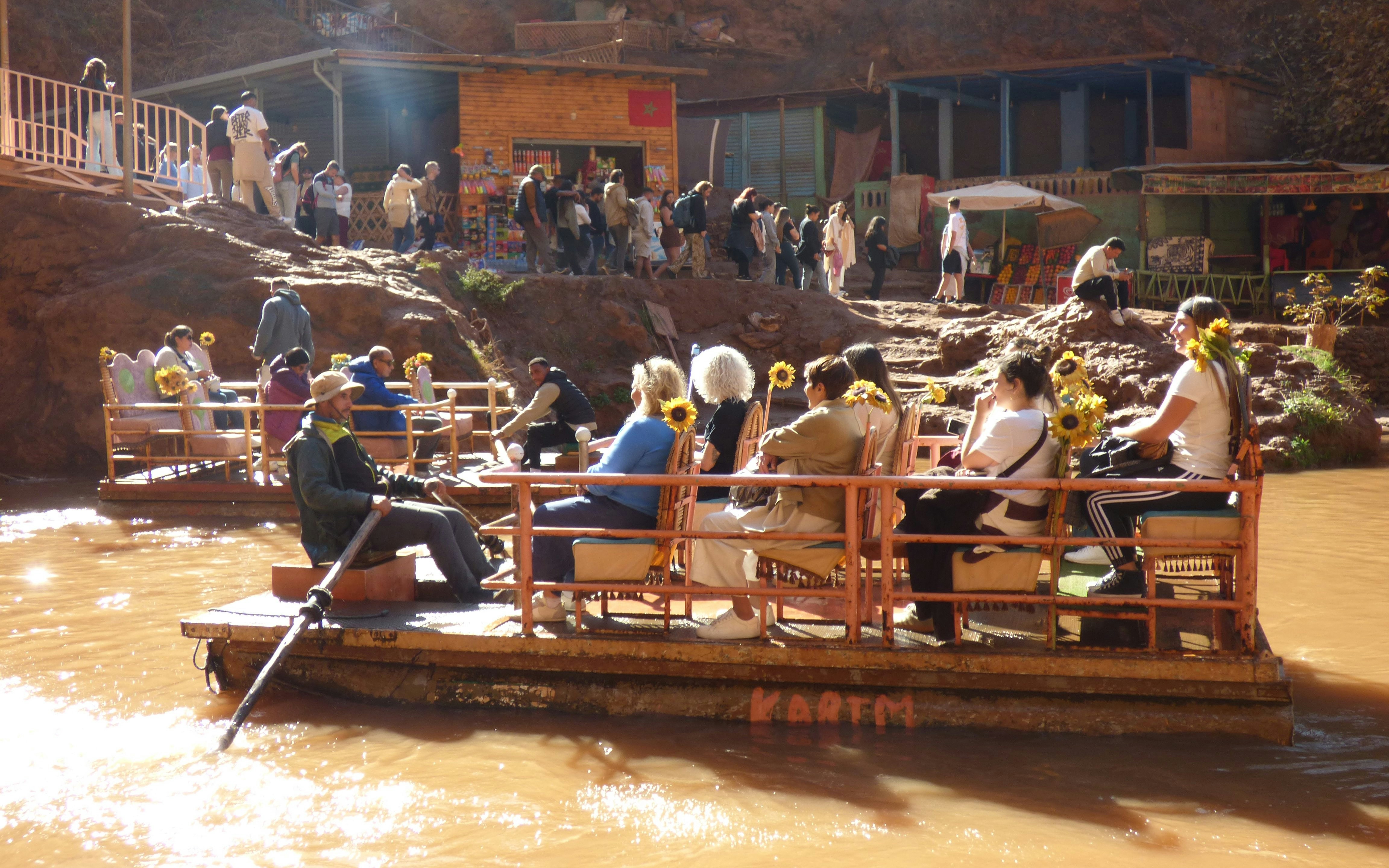 Tourists on a boat ride at Ouzoud Waterfalls, Morocco, with a guide rowing.